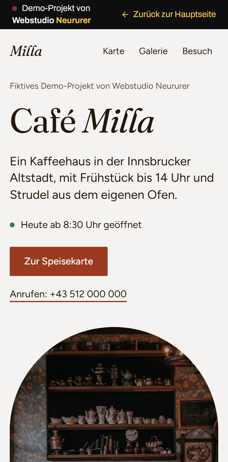Phone view of the made-up example website Café Milla: opening status, call link and a Visit menu item at the top