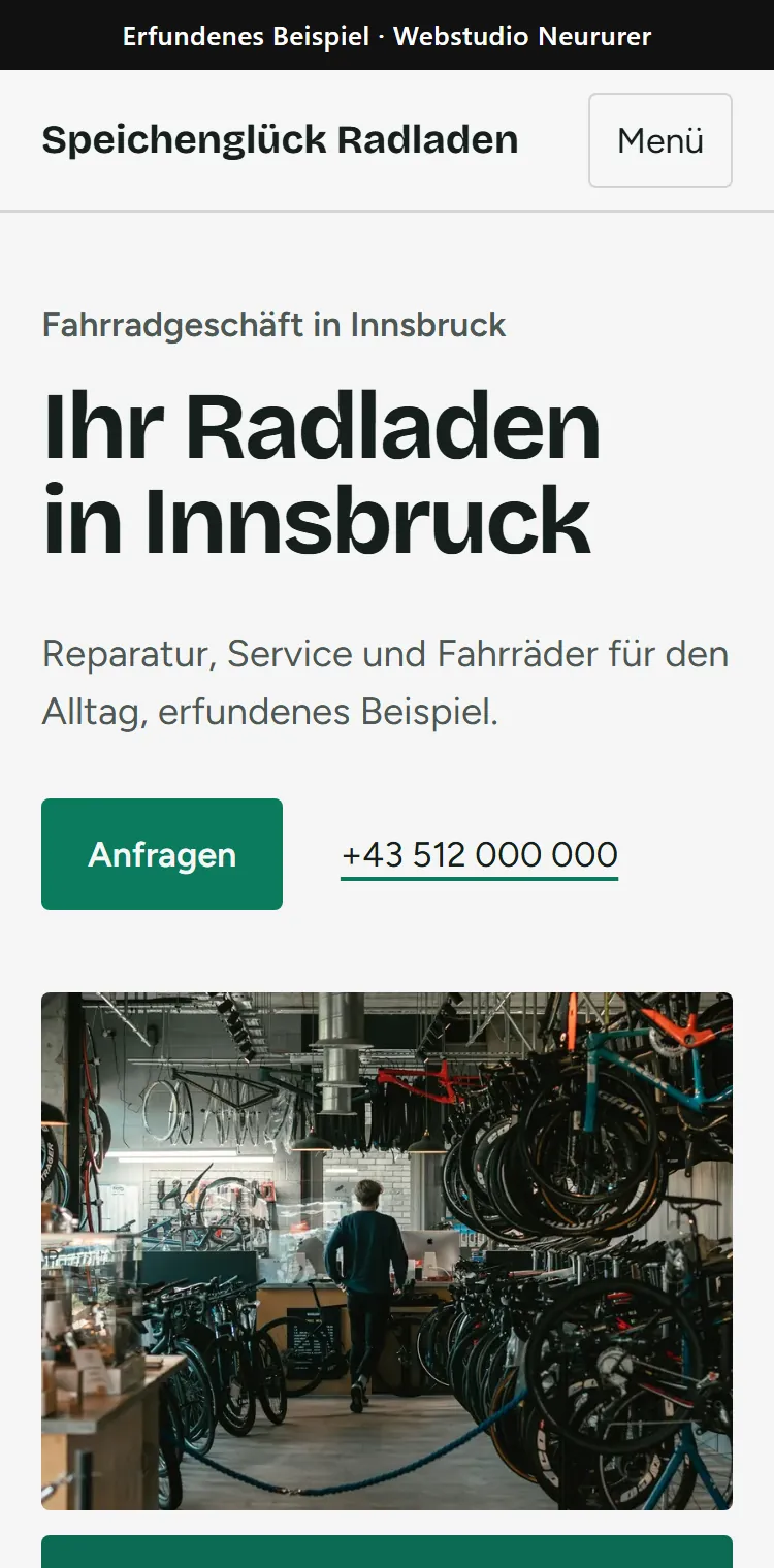Handy-Ansicht der erfundenen Beispiel-Website Speichenglück Radladen: Überschrift, Anfrage-Knopf, Telefonnummer und Foto einer Fahrradwerkstatt